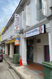 a building with a hotel sign on a street at Philip Hotel at Little India in Singapore
