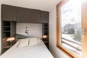 une chambre avec un lit et une fenêtre donnant sur un télésiège dans l'établissement Les Cimes - Immodreams - Avoriaz, à Avoriaz