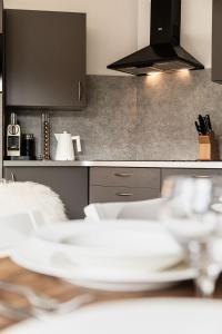 une cuisine avec une table avec de la vaisselle blanche dessus dans l'établissement Les Cimes - Immodreams - Avoriaz, à Avoriaz