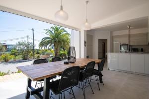 a kitchen and dining room with a wooden table and chairs at Pomba beautifully renovated with heated pool! in Poço Partido