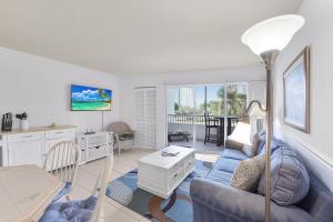 a living room with a couch and a table at Relaxing inland condo with pool and steps to beach in Marco Island