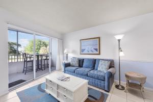 a living room with a couch and a table at Relaxing inland condo with pool and steps to beach in Marco Island