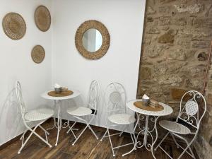 a room with three tables and chairs and a mirror at Il Querceto Relais in Gerace