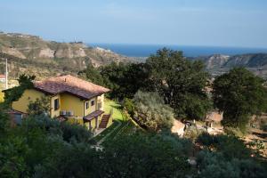 a house on a hill with mountains in the background at Il Querceto Relais in Gerace