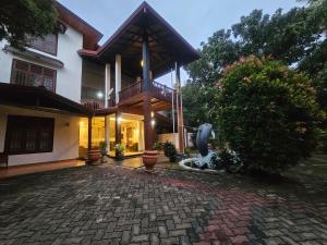 a house with a statue in front of it at Pearl City Hotel & Yala Safari in Tissamaharama