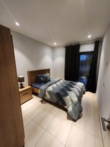 萨拉昆达Cozy 2BR ForestView Apt - Garden的带床和窗户的卧室