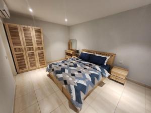 萨拉昆达Cozy 2BR ForestView Apt - Garden的卧室里有一张床，床铺有蓝白相间的被子