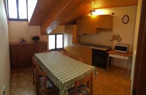 a kitchen with a table and a kitchen with a stove at Altipiani Trentini in Lavarone