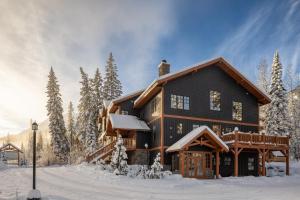 a large wooden house with snow on the ground at Copper Horse Lodge in Golden