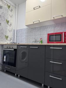 a kitchen with a stove and a microwave at National Stadium Aparment in Bucharest +19 photos