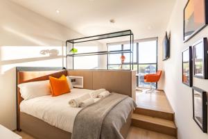 圣安德鲁斯The SPACE To Stay Aparthotel的卧室里有一张带橙色枕头的床