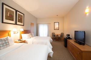 a hotel room with two beds and a television at Banff Inn in Banff