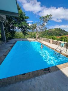 a group of people swimming in a blue swimming pool at Tibline by Gotravelfix in Kudadeniya