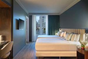 a bedroom with a large white bed and a window at NH Collection Buenos Aires Lancaster in Buenos Aires