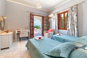 a bedroom with two beds and a table and a desk at Villa Kyklamino in Ieromónachos