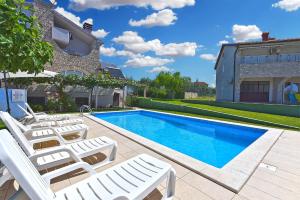 a swimming pool with lounge chairs next to a house at Room with pool 2371 in Medulin