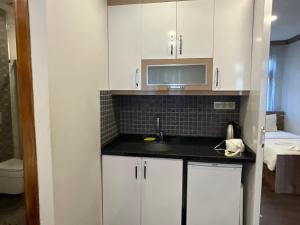 een keuken met witte kasten en een spoelbak bij KAMER Apart Hotel in Istanbul +69 foto's