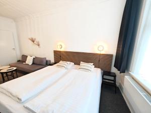 a bedroom with two beds and a couch at CentralHotellet in Køge