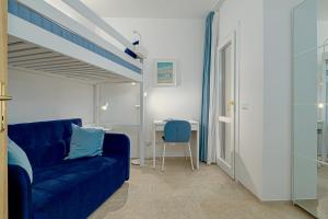 a living room with a blue couch and a table at Appartamento Vista Marina direttamente sulla spiaggia con vista mare in Golfo Aranci