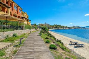 a wooden walkway next to a beach next to a building at Appartamento Vista Marina direttamente sulla spiaggia con vista mare in Golfo Aranci