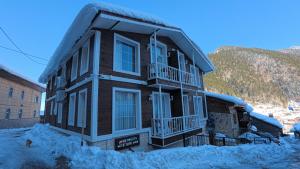 a house with snow on the ground in front of it at Rabando Suit in Uzungol