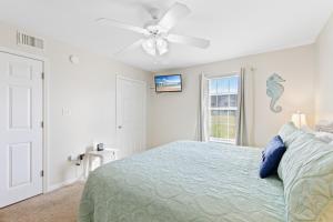 une chambre avec un lit et un ventilateur de plafond dans l'établissement Colony Club H6, à Gulf Shores