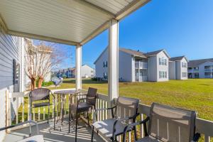 - une terrasse couverte avec des chaises, une table et une cour dans l'établissement Colony Club H6, à Gulf Shores