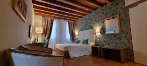 a bedroom with a bed and a mirror and chairs at UNAHOTELS Eco Hotel Villa Costanza Venezia in Mestre +92 photos
