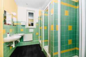 布拉格Benedikt City Center Hostel的浴室设有绿色和黄色瓷砖以及水槽