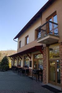 a building with a balcony and tables and chairs at Penzion Majak in Banská Bystrica