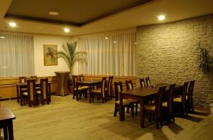 a restaurant with tables and chairs and a brick wall at Penzion Majak in Banská Bystrica