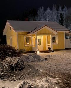 Talo Merikarvian keskustassa lähellä Merta! في Merikarvia: منزل اصفر ثلجي امامه