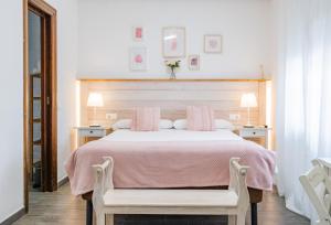 a bedroom with a bed with pink sheets and two chairs at El Nogal Home in Málaga