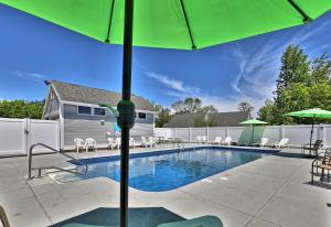 una piscina con ombrellone e sedie verdi di Spacious 2RM-2BA Condo in the Heart of the Town, Summer Pool, Shuttle Route a Killington