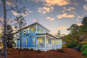 a blue house with large expanses of windows at Saffron Sands by Stay on 30A- Pool, Bikes, Golf Cart in Seagrove Beach