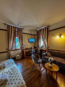 a bedroom with a bed and a couch and a desk at Grand Hôtel de France in Pierrefitte-Nestalas +30 photos