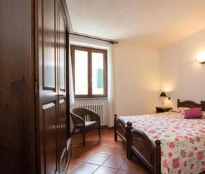 Un dormitorio con una cama y una silla y una ventana. en Agriturismo Il Colletto, en Albenga