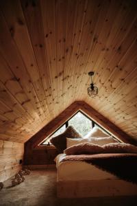 a bed in a room with a wooden ceiling at Forestic Lietuva in Vilionys