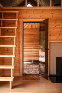 a sauna with a glass door in a wooden building at Forestic Lietuva in Vilionys