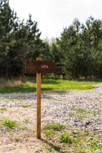 a wooden sign in the middle of a dirt road at Forestic Lietuva in Vilionys