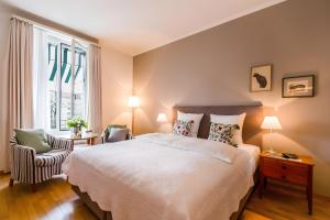una camera da letto con un grande letto bianco e una sedia di Boutique Hotel Seegarten a Zurigo