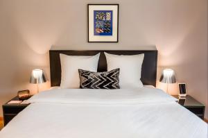 una camera da letto con un grande letto bianco con due lampade di Boutique Hotel Seegarten a Zurigo