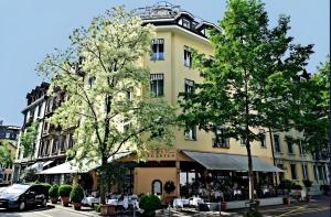 un edificio giallo con alberi di fronte di Boutique Hotel Seegarten a Zurigo