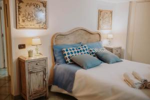 a bedroom with a large bed with blue pillows at San Gregorio Luxury Apartments in Naples
