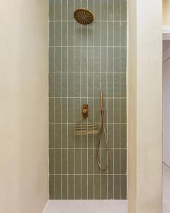 una doccia con piastrelle verdi in un bagno di Koukaki Jacuzzi Retreat ad Atene