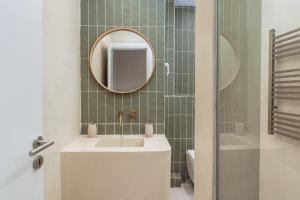 un bagno con lavandino e specchio di Koukaki Jacuzzi Retreat ad Atene