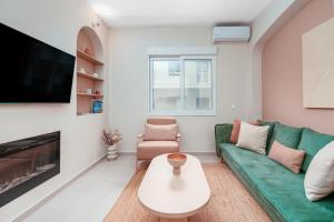 un soggiorno con un divano verde e una TV di Koukaki Jacuzzi Retreat ad Atene