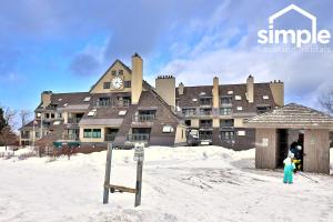 キリングトンにあるMountain Green 3C16 - Renovated 2BR-2BA With Mountain Views, Hot Tub, Pool, Shuttle, Gymの雪時計付きの大きな建物
