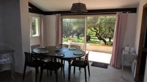 une salle à manger avec une table et des chaises et une fenêtre dans l'établissement Maison 55m2 cadre campagne, le mas des anges, à Sanary-sur-Mer
