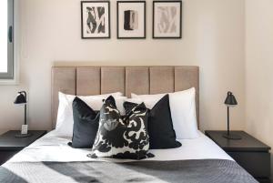 a bedroom with a bed with black and white pillows at Phaedrus Living Evergreen Nicosia City Residence in Nicosia